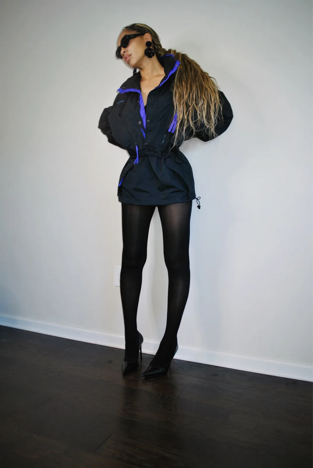 Black zip windbreaker with purple collar styled with black stilettos